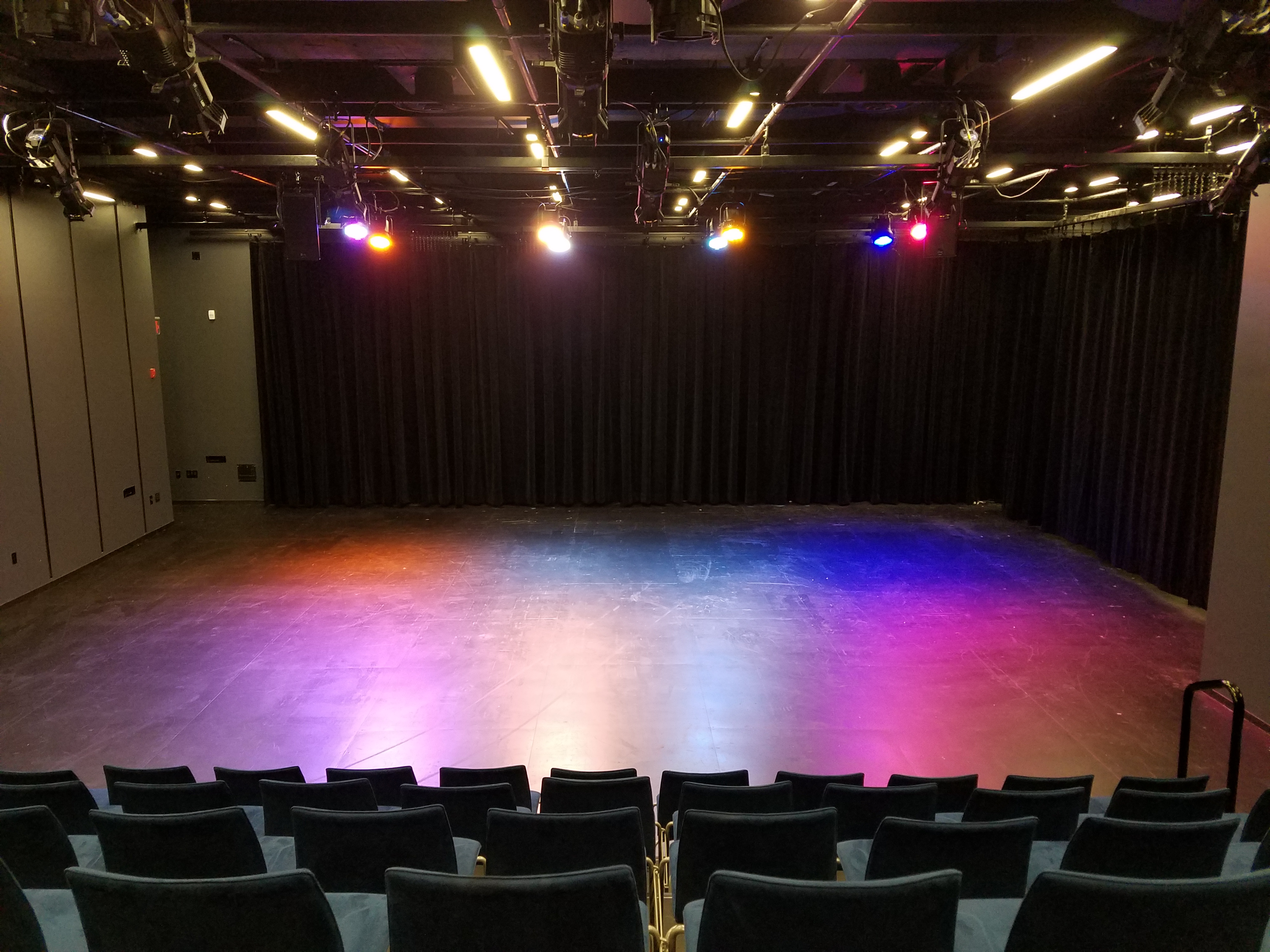 Photo of the Mezzanine Theatre in the proscenium configuration with colorful wash.