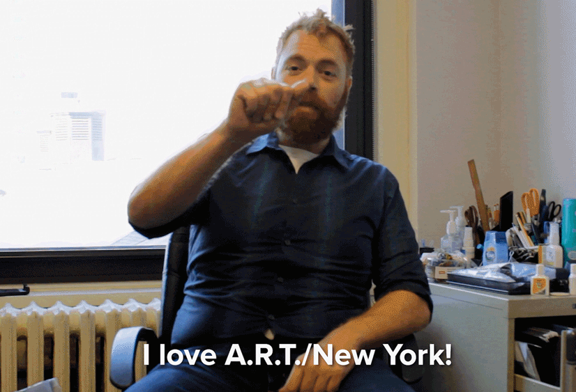 A man signing "I love ARTNY" in ASL.